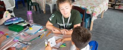 Projects Abroad teaching volunteer in Belize helps her student pronounce English words correctly A volunteer helps improve the literacy skills of her students during her teaching work experience in Belize